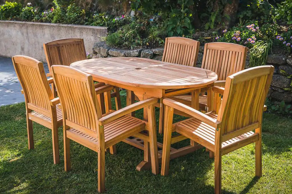 Teak Fixed Oval pedestal table With 6 stacking Charlotte chairs